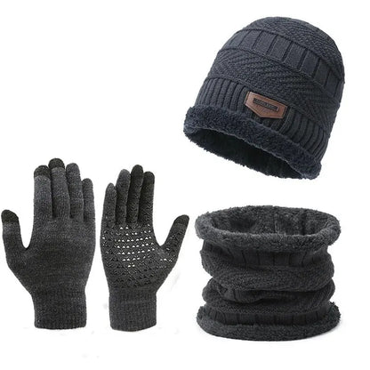 Set of dark gray knit beanie, gloves, and scarf on a white background